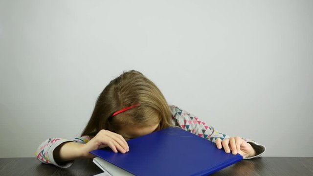 The child spies in the book for adults. An inquisitive girl looks in a secret book.