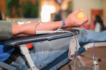 Blood donor at donation with a bouncy ball holding in hand.
