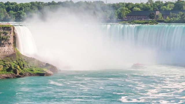 Time lapse view of tourist boats going into the mist of Horseshoe Falls at Niagara Falls, on the border of United States and Canada. Zoom out.