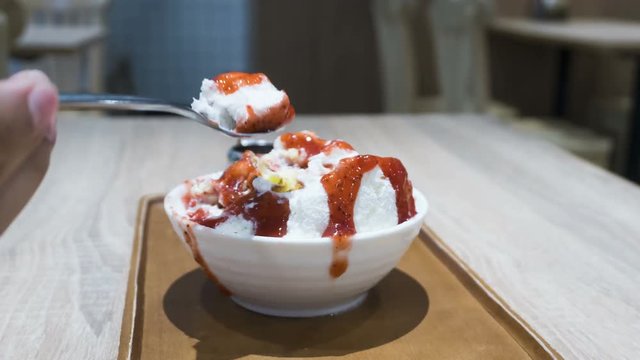 Time lapse of Bingsu, The shaved ice with slightly milk cream topped with cream cheese and fresh strawberry. Woman hand strawberry stack. 