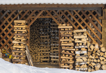 rustic barn for storage of firewood, stacked firewood