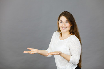 Happy woman presenting copyspace with hands