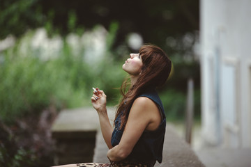 woman sitting in the backyard, smoking