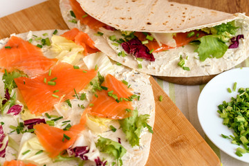 Pancakes with smoked salmon, cream cheese, chives and lettuce.