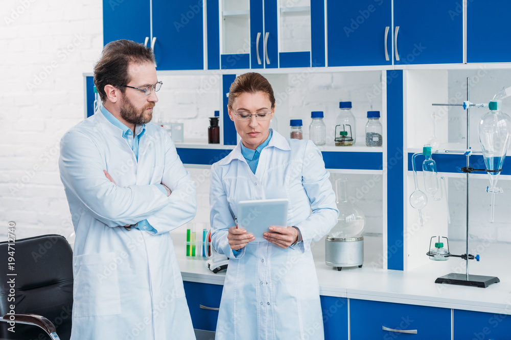 Wall mural portrait of scientific researchers in lab coats with digital tablet in laboratory