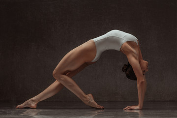 Fototapeta na wymiar Young yoga woman stretching and training in class