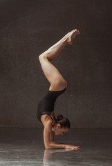 Young yoga woman stretching and training in class