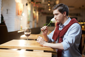 Young man sitting at cafe and waiting for his girlfriend