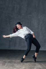 Young beautiful female dancer is posing in the studio