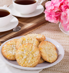 Pie of lemon crackle cookies on a plate and cups of coffee in background