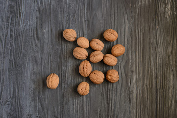 Walnut kernels and whole walnuts on rustic old wooden table