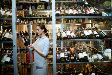 Waitress choosing a good wine for client of the restaurant