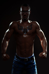 Muscular man posing in studio on dark background