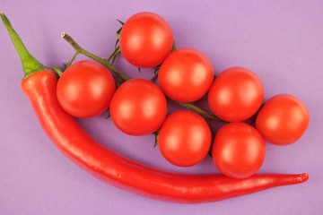 Red  cherry tomato 
Red  cherry tomato and red cayenne pepper on a purple  background

