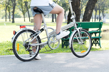 Fototapeta premium Close up young woman riding bike bicycle in the natural public park