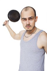 Emotional portrait of an angry fit caucasian man holding frying pan as a baseball bat, ready to make a hit (strike), to beat someone. Isolated on white
