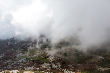 Fototapeta na wymiar mountain view with thick clouds down to the lowland in Montenegro