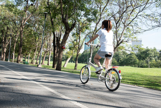 Close up young woman riding bike bicycle in the natural public park