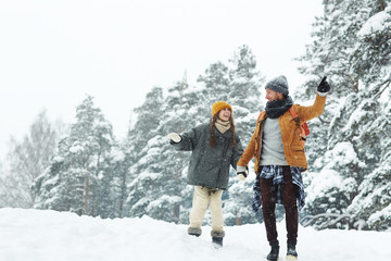 Fototapeta na wymiar Young travelers enjoying their trip in winter forest on snowy day