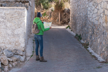 Woman tourist is looking at the map on the street of city