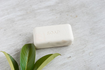 natural organic soap with green leaves on wooden background