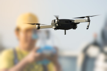 flying drone with blurred controller in background
