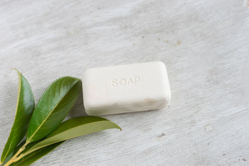 Obraz na płótnie Canvas natural organic soap with green leaves on wooden background