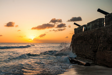 Sun Set over a Historic Beach in Barbados, Stone Wall, Cannons  - obrazy, fototapety, plakaty