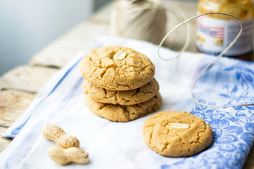 Freshly baked homemade peanut butter cookies on the cotton cloth on the wooden tablee