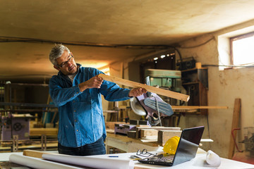 middle aged wood engineer working in his workshop