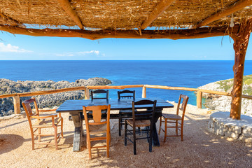 Table and chairs in traditional Greek tavern with view of beautiful Ionian sea. Zakynthos. Zante, Greece