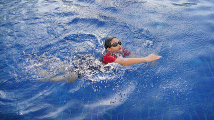 Happy children in the swimming pool. Funny kids playing outdoors. Summer vacation concept