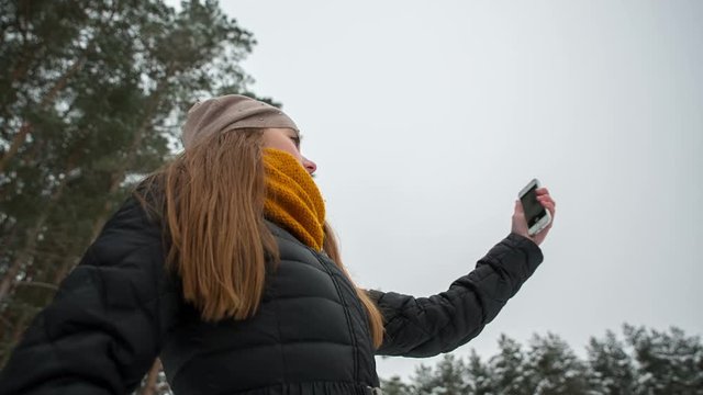 Girl makes selfie in the winter park