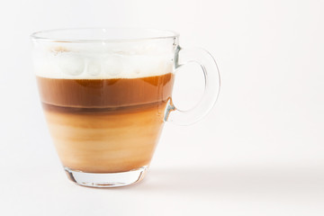 Coffee cappuccino in a transparent cup and saucer on a white background