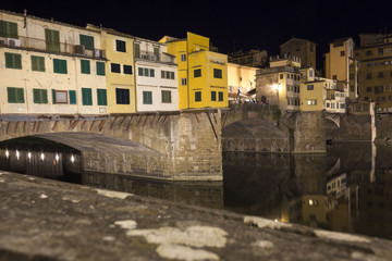 Fototapeta na wymiar Lateral view at night of historic bridge in Florence, Italy