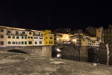 Fototapeta na wymiar Lateral view at night of historic bridge in Florence, Italy