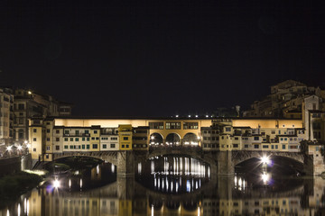 Fototapeta na wymiar Night view of the historic Ponte Vecchio bridge in Florence on Arno river