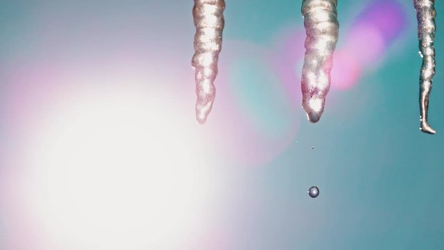 Zoom to closeup of icycles from a roof in a sunny day
