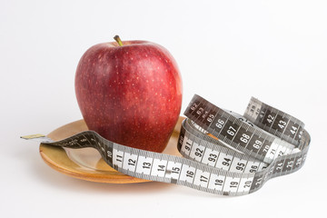 Apple on white background with measuring tape