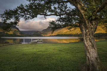 Landscape image of rowing boats on Llyn Nantlle in Snowdonia at sunset