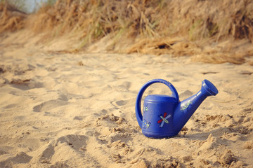 Childs toy water jug on sandy beach