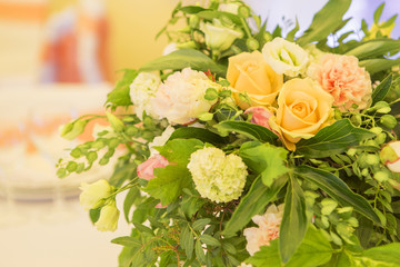 Simple but luxury rich table setting for a wedding celebration in nice cozy restaurant. Wineglasses, plates and bouquet of summer seasonal flowers on a table. Sunlight from a window. Copy space