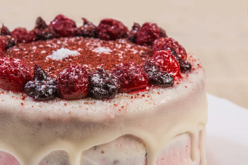 round fruit cake with berries and cream close-up