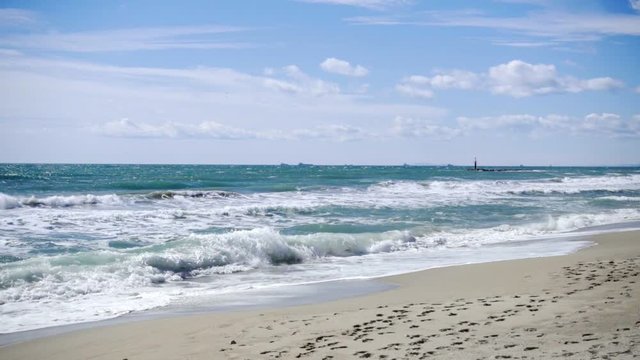 Slow motion 120fps shoot of sea waves breaking on a sandy beach. Mediterranena sea waves in Altafulla, Spain.