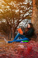 young woman reading a book in park