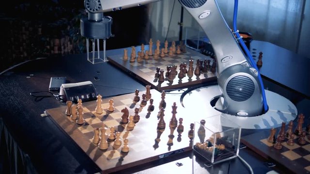 A robotic arm is moving chess pieces and pressing the chess clock