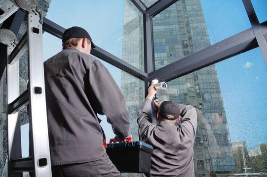 Installation of video surveillance, security system, security specialist at work. Interior, skyscraper in the background