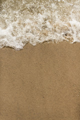 Fototapeta na wymiar smooth sand and gentle water crashes on the beach