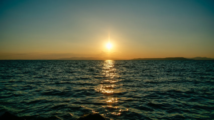 Obraz premium Sunset at sea, against islands