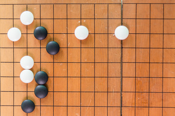 Game's white and black stone on cross board.